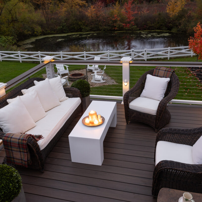TimberTech Mocha Legacy Collection composite deck with white railings and built-in post cap lighting.